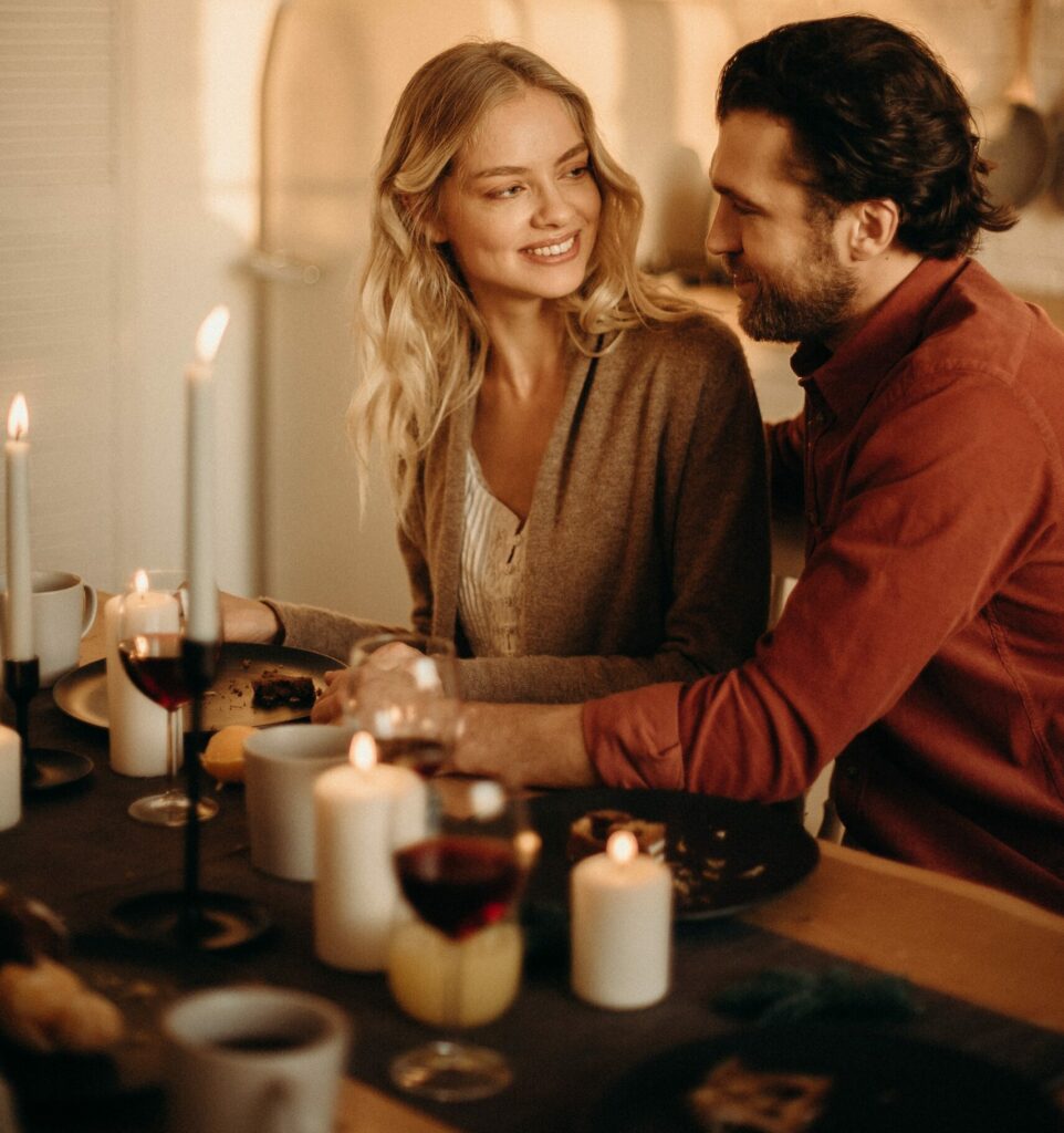 Man and Women Looking at each other in a candlelit Kitchen With a Romantic Vibe